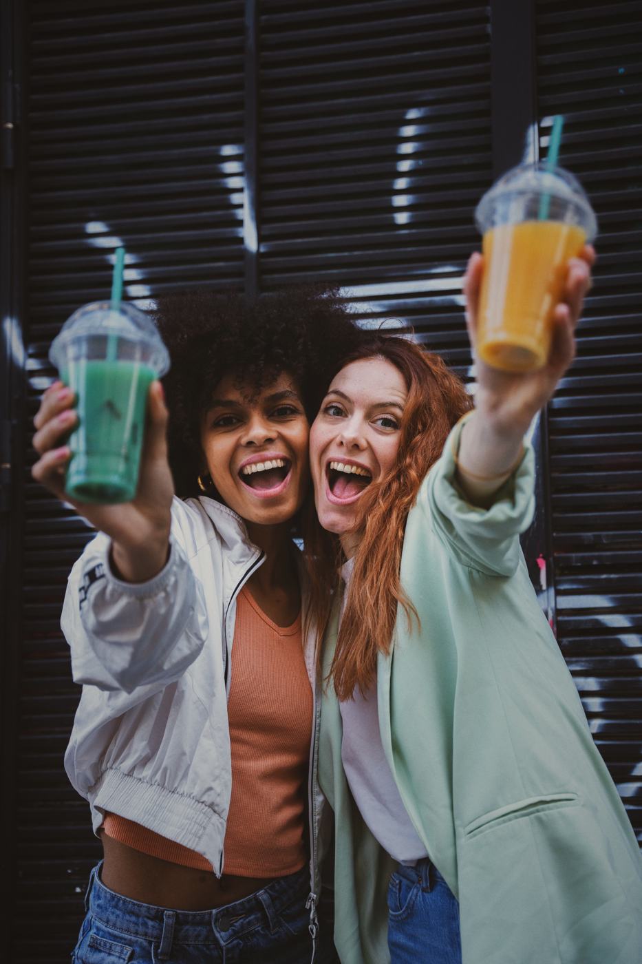 Deux amies devant un mur peint, sacs SUYA à la main