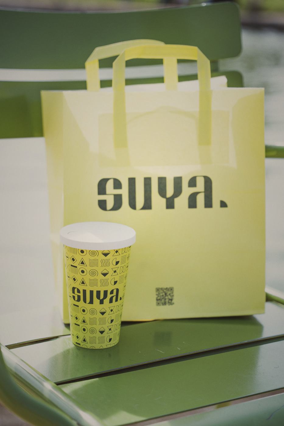 Le sac kraft SUYA et son gobelet sur une table de terrasse